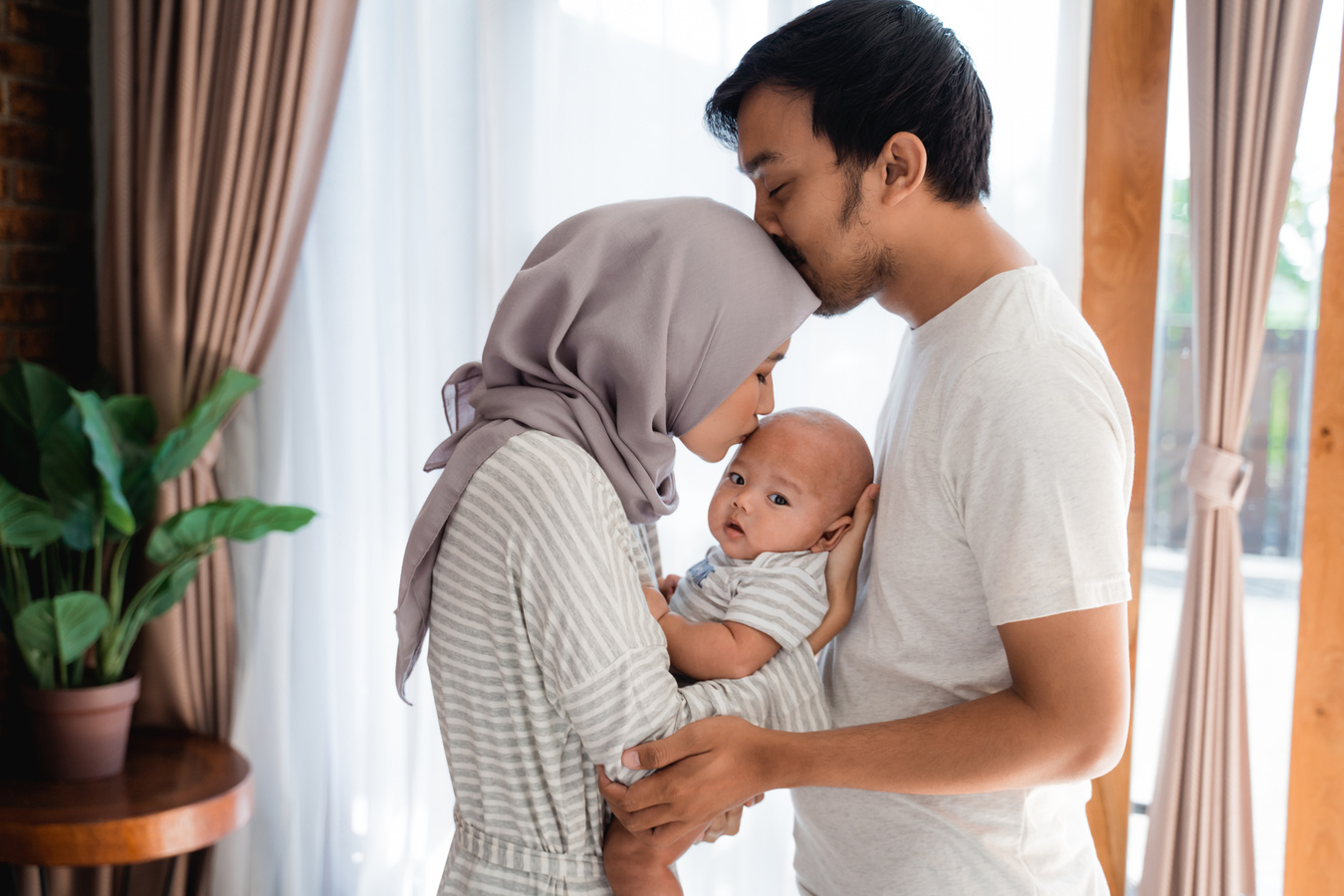 Muslim Parent Kissing Together with Baby Boy